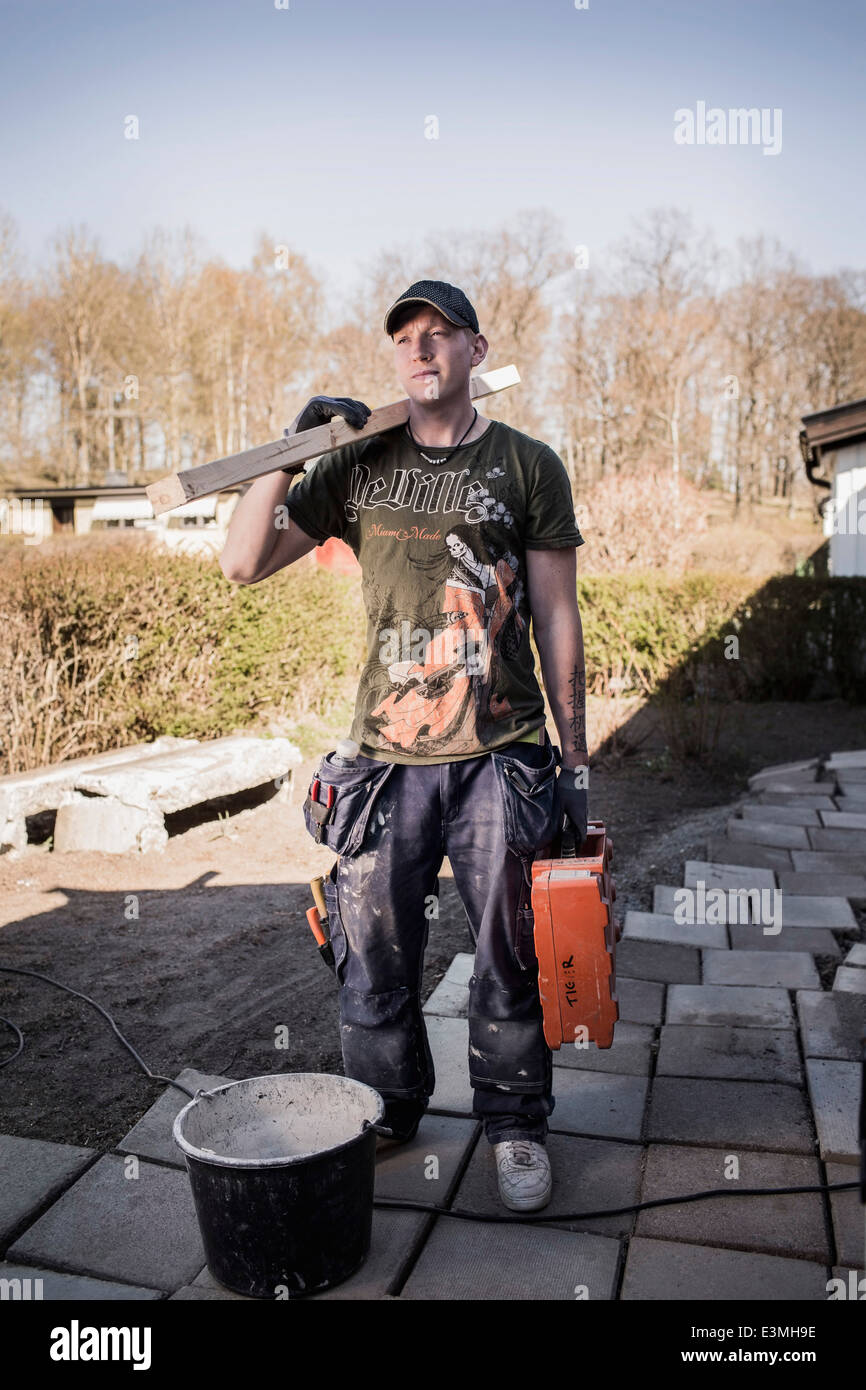 Männliche Zimmermann mit Holzbrett und Toolbox stehen am Standort Stockfoto