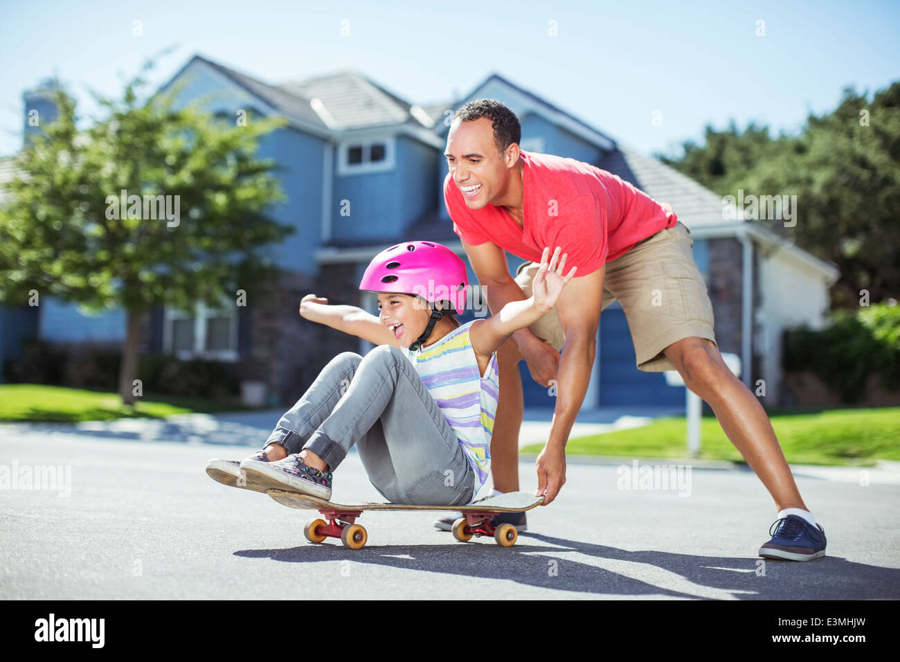 Vater drängen Tochter auf skateboard Stockfoto