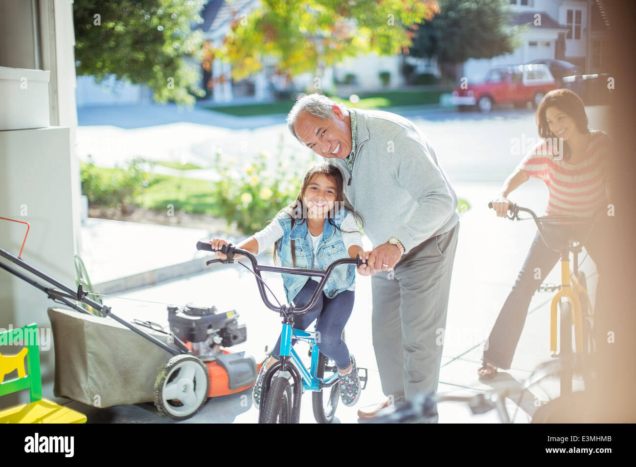 Großvater und Enkelin auf Fahrrad in garage Stockfoto
