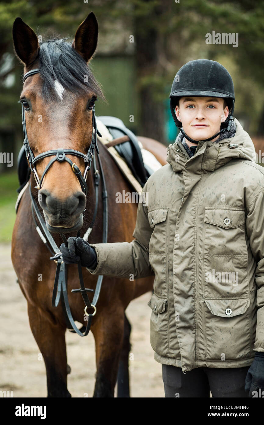 Porträt des jungen Mannes mit Pferd stehen im freien Stockfoto