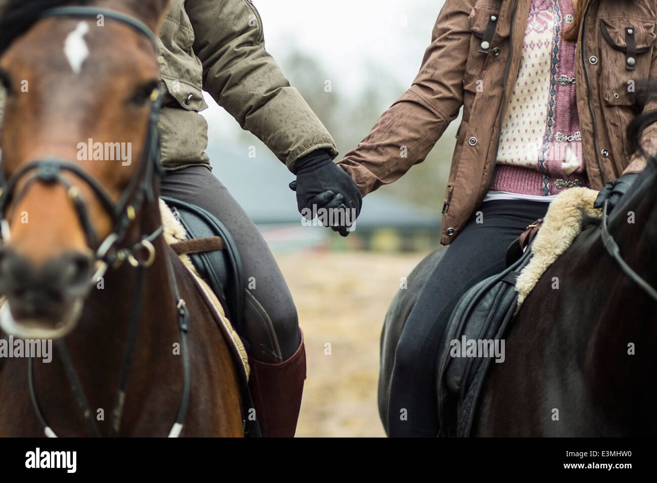 Geringen Teil der paar Hand in Hand beim reiten Pferde Stockfoto