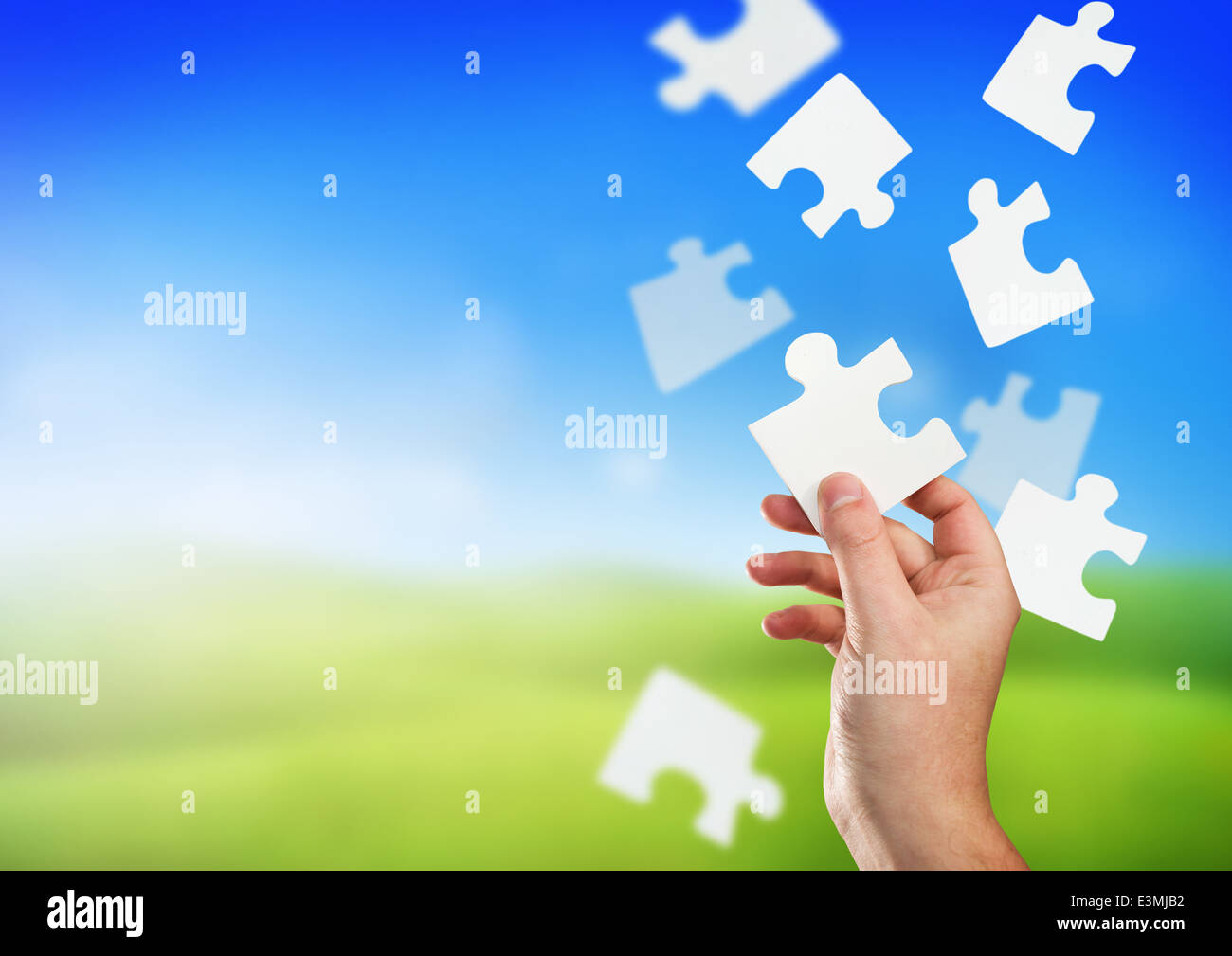 Ein Mann hält das richtige Stück des Puzzles. Stockfoto