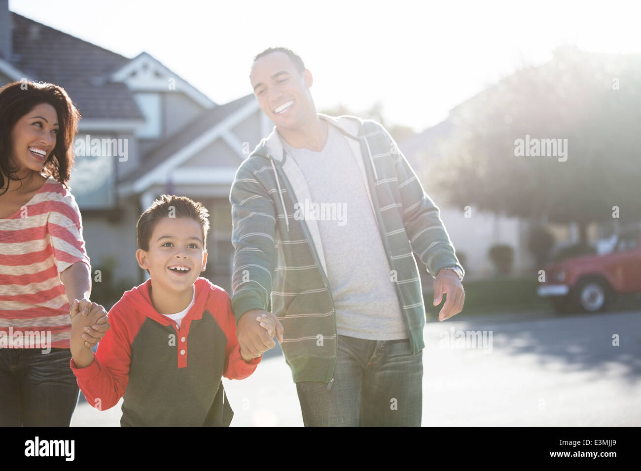 Glückliche Familie laufen auf sonniger Straße Stockfoto