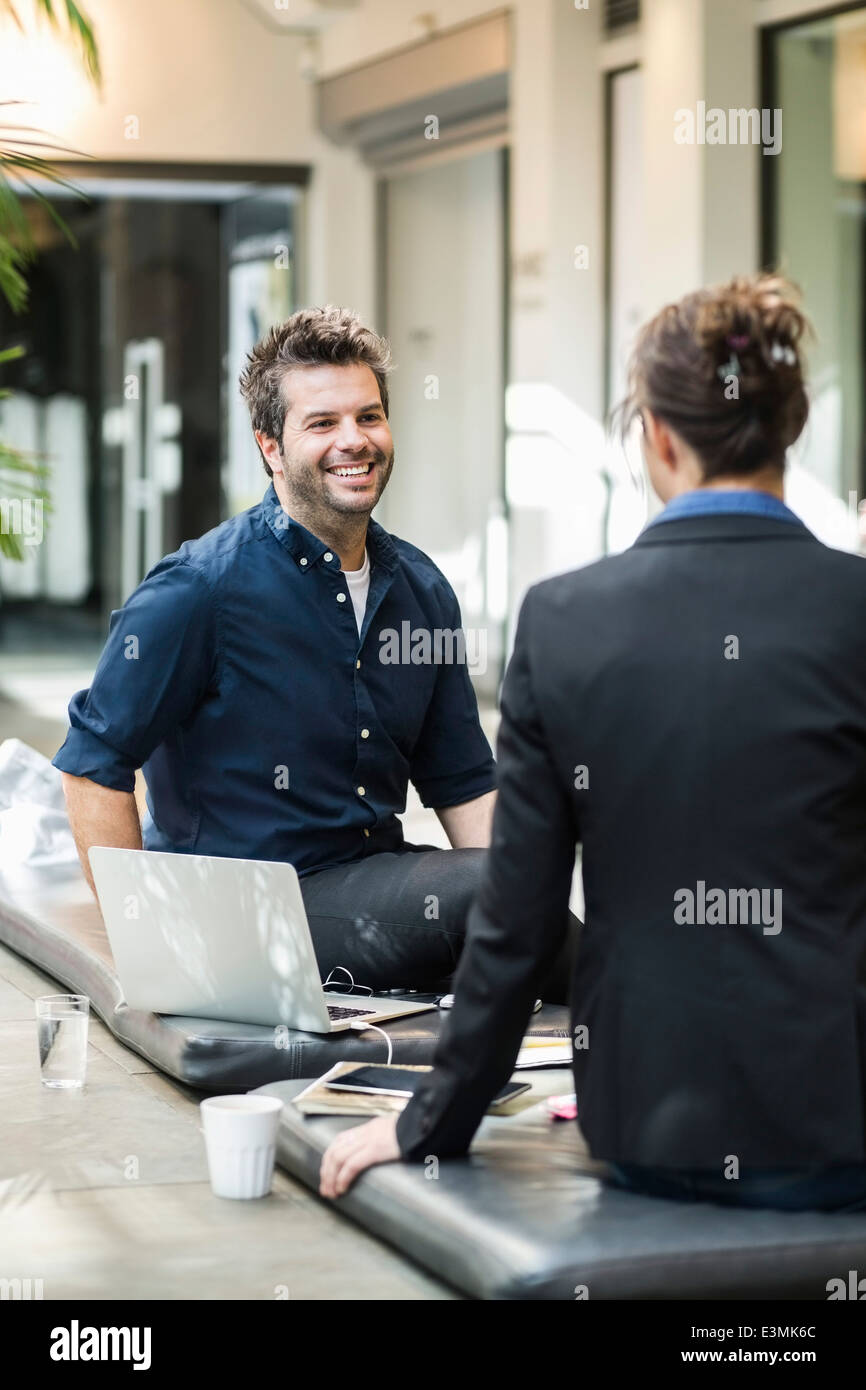 Lächelnd Mitte adult Geschäftsmann diskutieren mit Kollegin im café Stockfoto