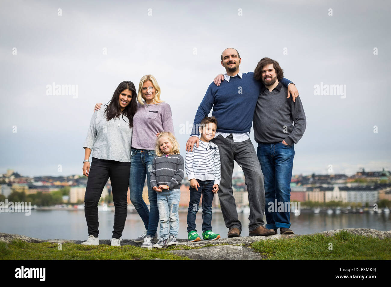 In voller Länge Portrait von Homosexuellen Familien zusammenstehen am Seeufer Stockfoto