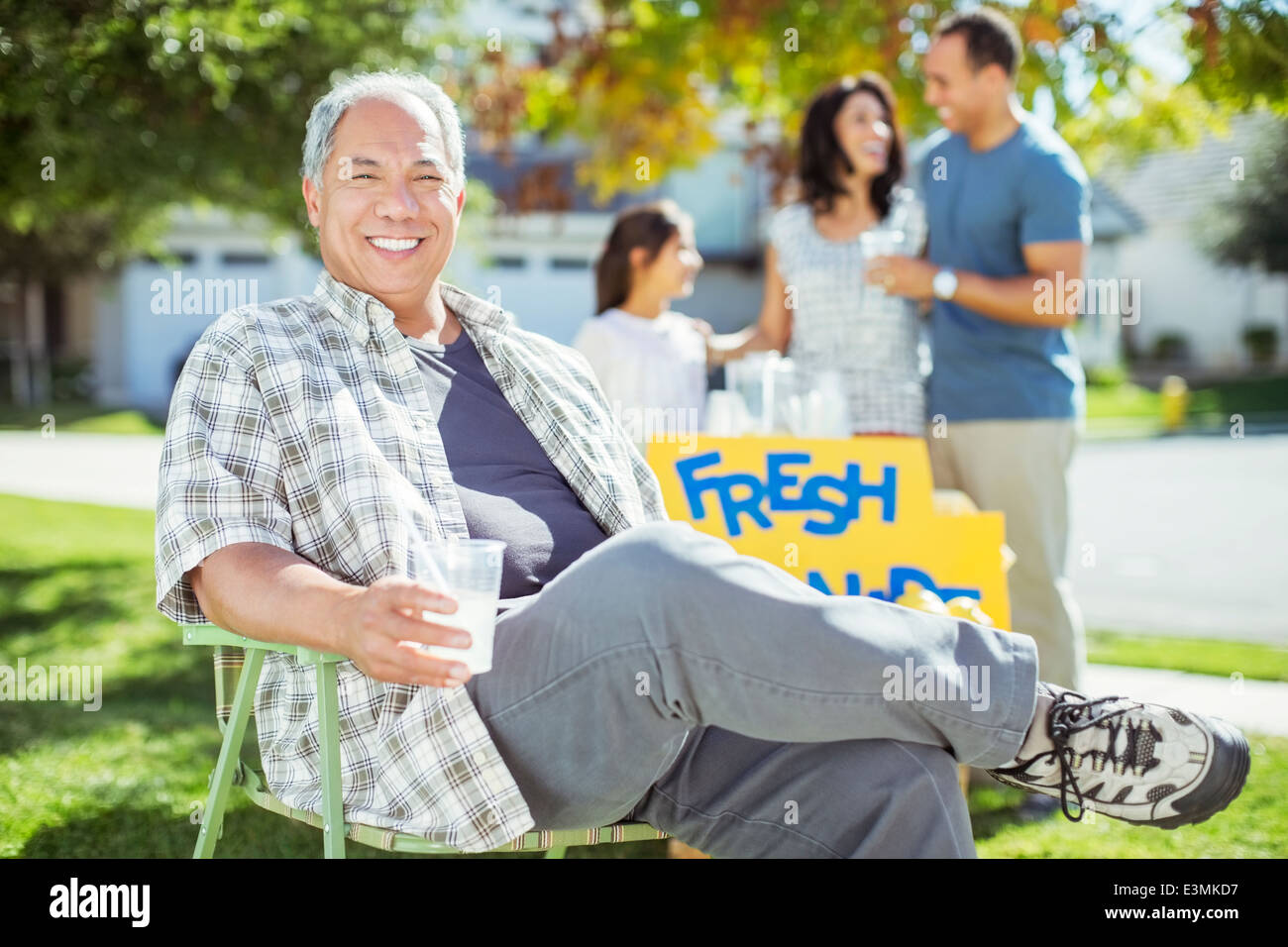 Porträt des lächelnden Menschen trinken Limonade in der Nähe von Limonadenstand Stockfoto