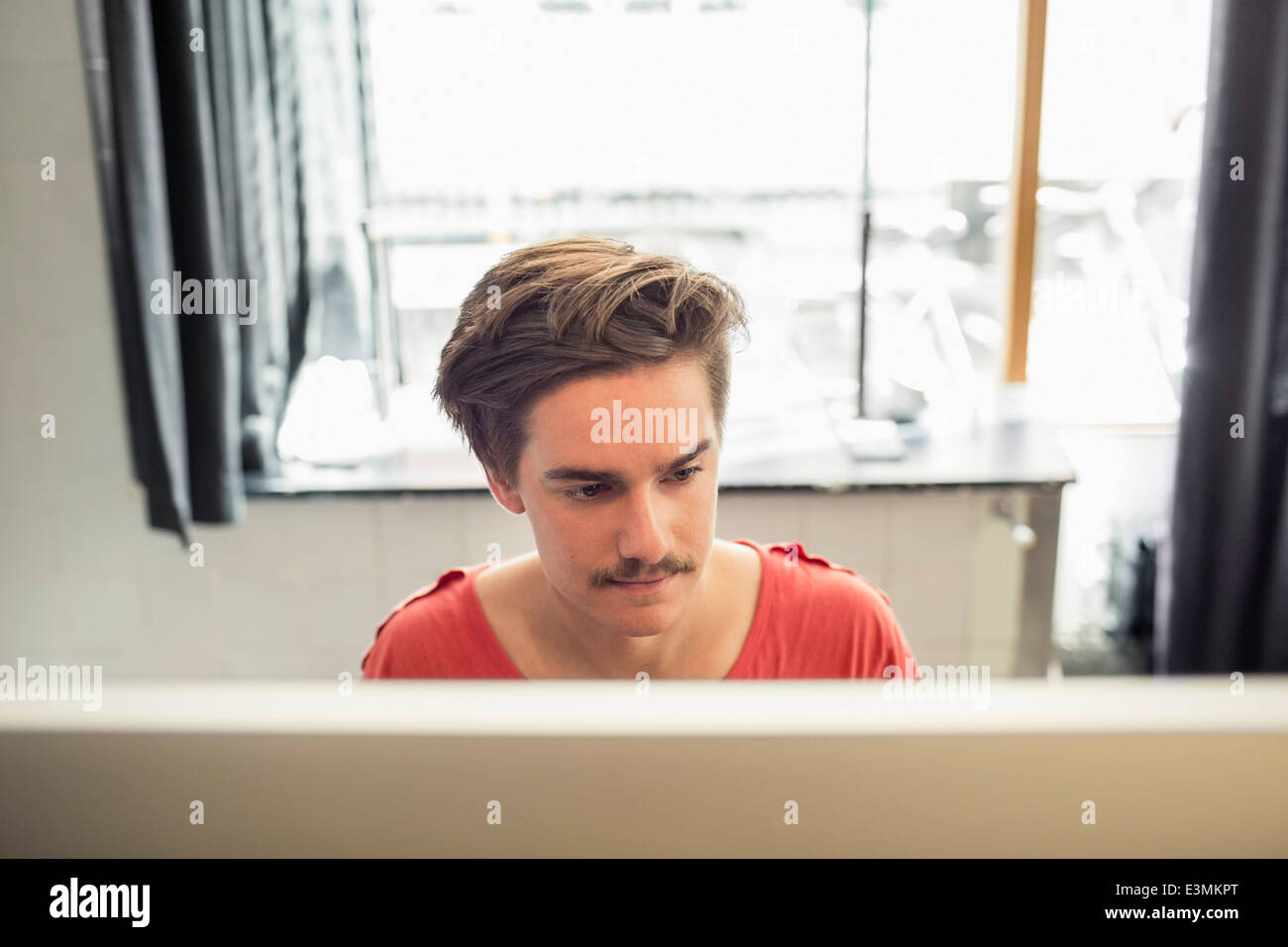 Konzentrierte junger Geschäftsmann mit Computer im neuen Büro Stockfoto