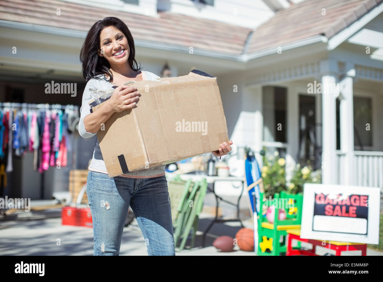 Portrait von lächelnden Frau mit Box am Hof-Verkauf Stockfoto
