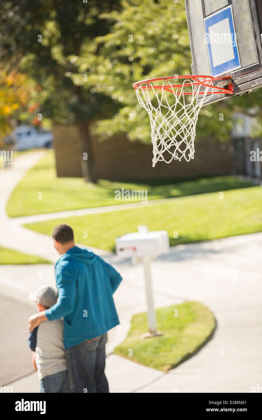 Vater und Sohn in der Nähe von Basketballkorb umarmt Stockfoto