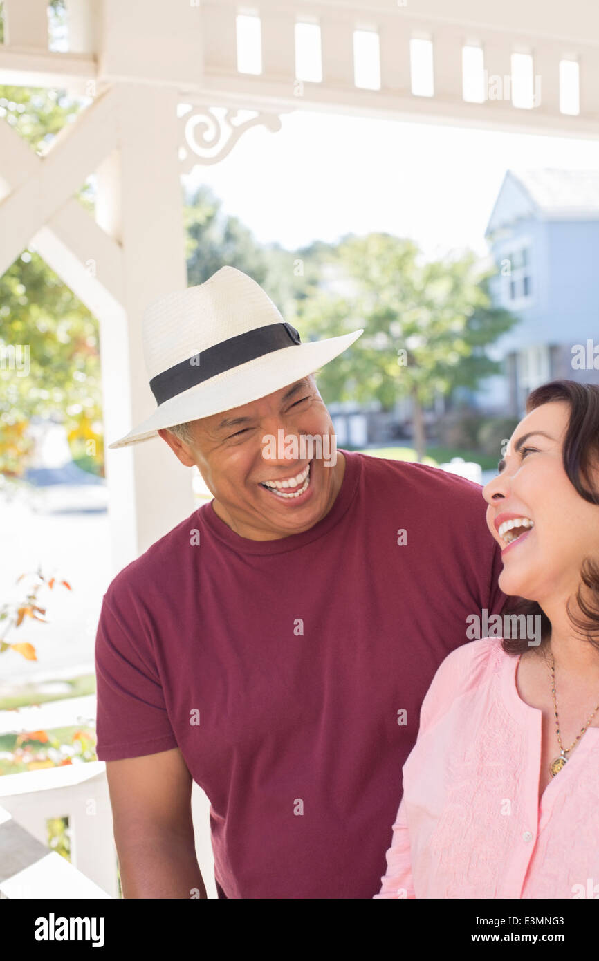 Paar lachend auf sonnige Veranda Stockfoto
