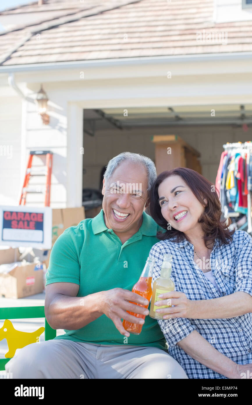 Porträt des glücklichen Paares Toasten Soda-Flaschen auf Flohmarkt Stockfoto