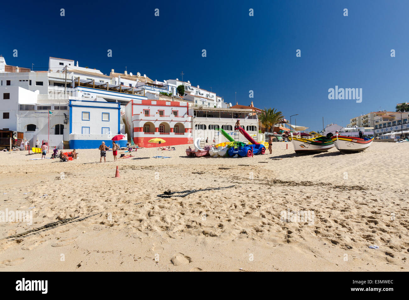 Urlauber am Sandstrand in der kleinen Küstenstadt Carvoeiro an der Algarve Stockfoto