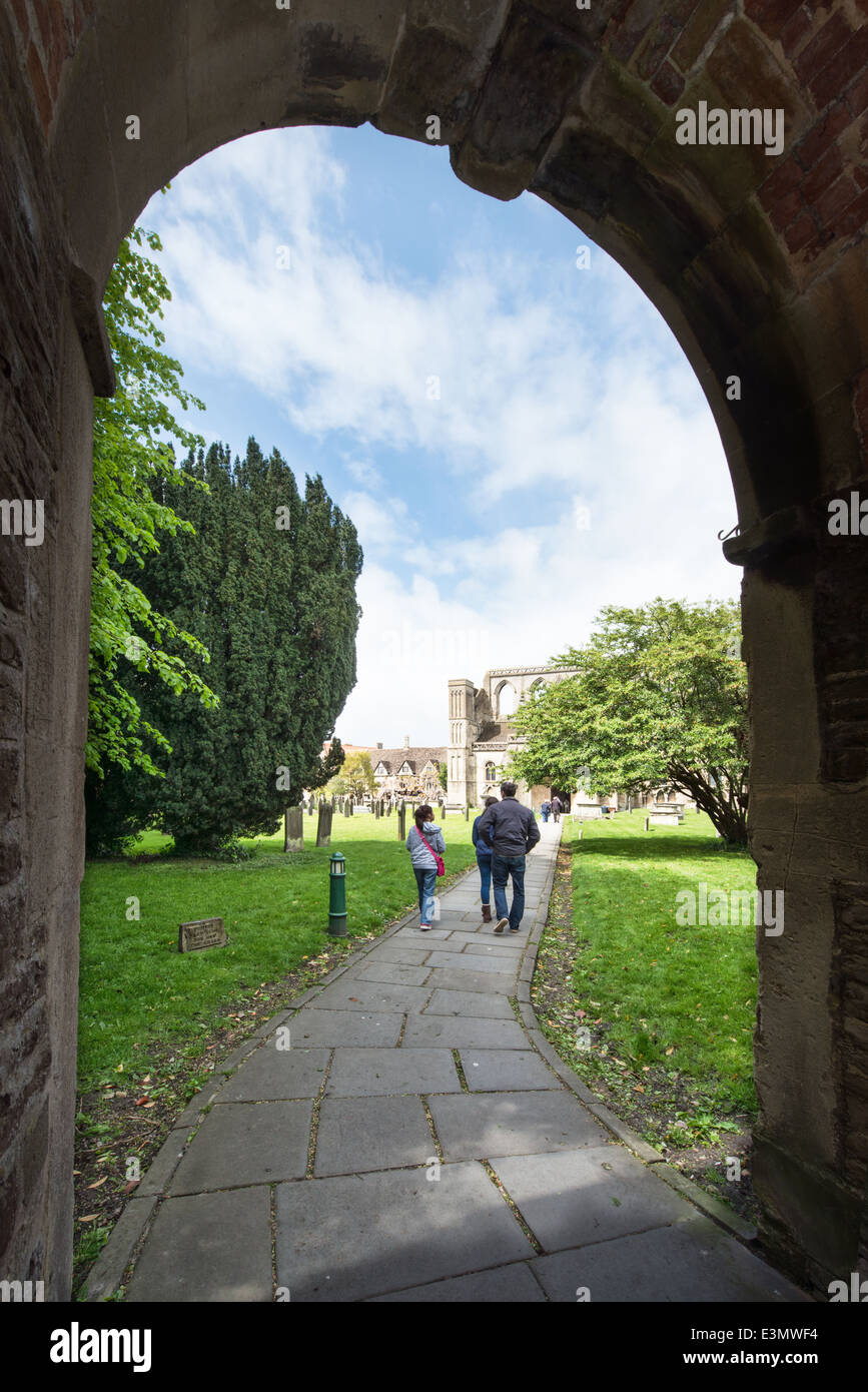 Besucher in Malmesbury Abbey & den Weg aus dem Bogen des Haupteingangs im Sommer Stockfoto