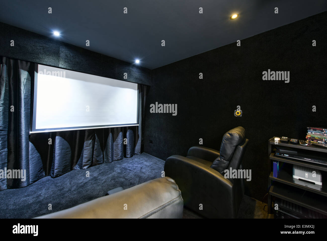 Das Innere eines inländischen Heimkino-Theaters mit Drop-down-Bildschirm, HD-Projektor & Surround sound-System ausgestattet Stockfoto