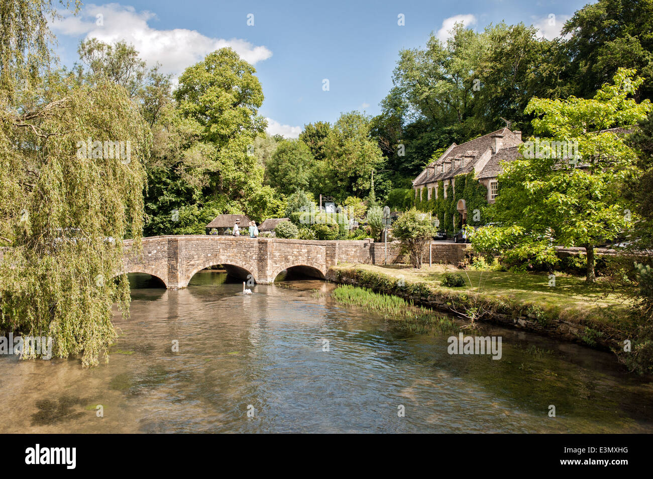 Die Brücke über den Fluss Coln & das Swan Hotel in der hübschen Cotswold Dorf Bibury, Gloucestershire, UK an einem Sommertag Stockfoto