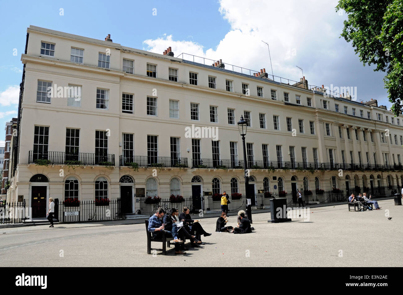 Menschen sitzen auf Bänken Essen in Fitzroy Square, Bloomsbury London England UK Stockfoto