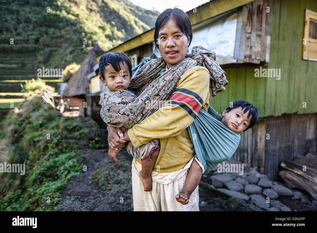 Frau, die ihre beiden Söhne mit einem Tuch auf ihren Schultern, Luzon, Philippinen, Asien Stockfoto