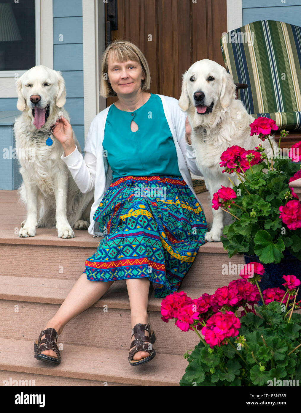 Frau posiert für Fotos auf Veranda mit zwei Platin farbige Golden Retriever Hunde Stockfoto