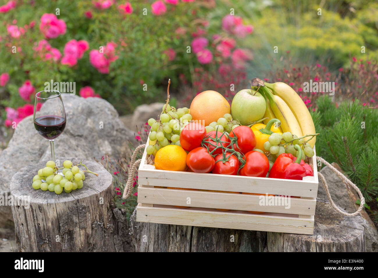 Kiste mit Mischung aus Obst und Gemüse im Garten