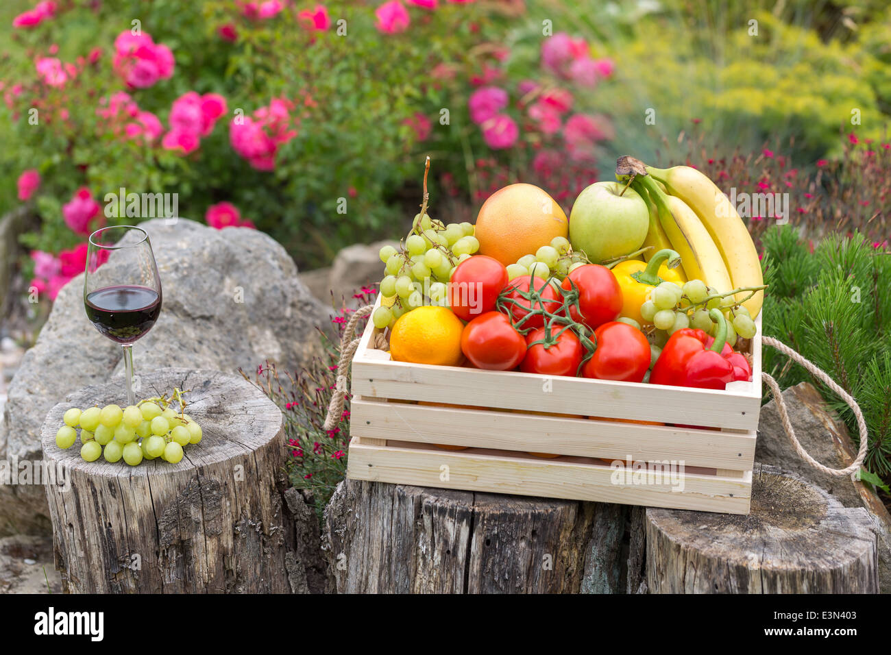 Kiste mit Mischung aus Obst und Gemüse im Garten