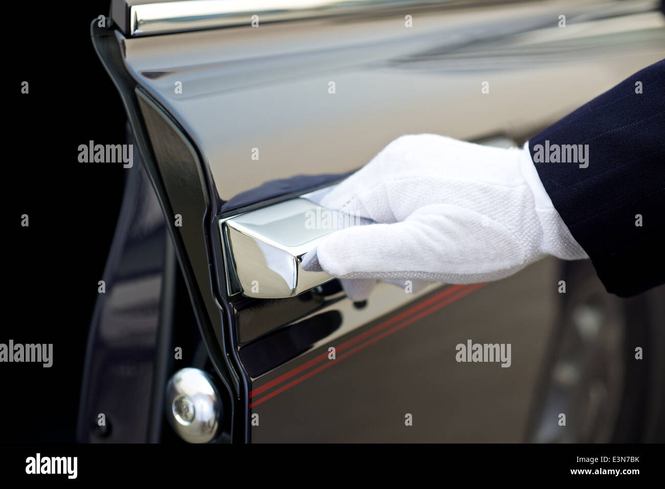 Chauffeur öffnet Autotür von einem Rolls royce Stockfoto
