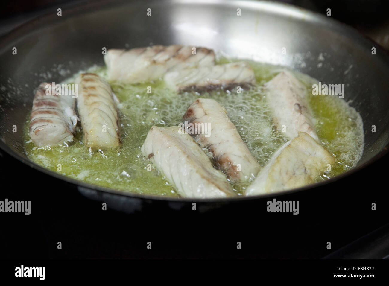 Nahaufnahme von Fisch in Pfanne braten Stockfoto