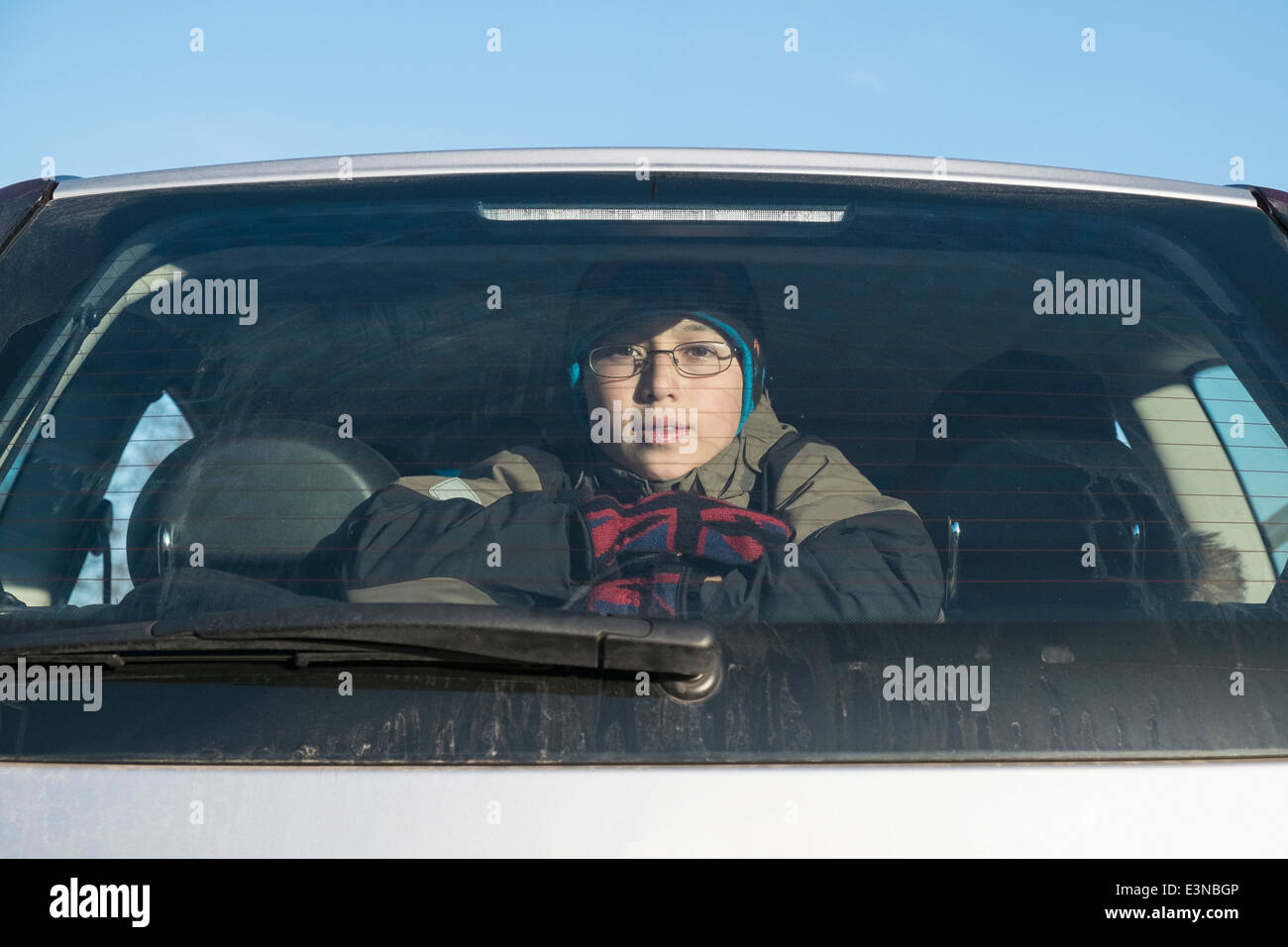Porträt von zuversichtlich Jungen suchen durch Autofenster Stockfoto