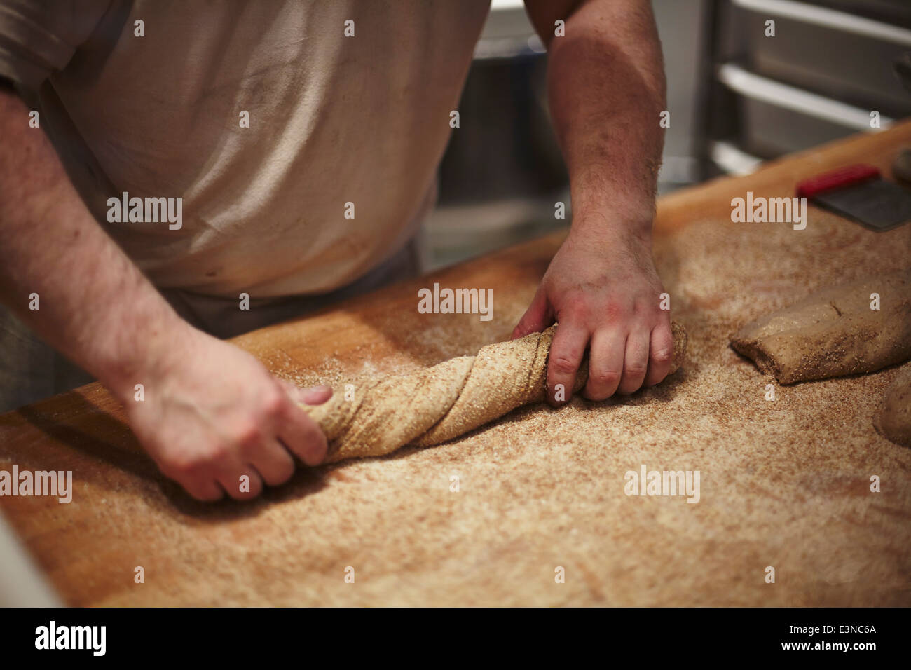 Mittleren Bereich des Mannes Vorbereitung Brot am Küchentisch Stockfoto