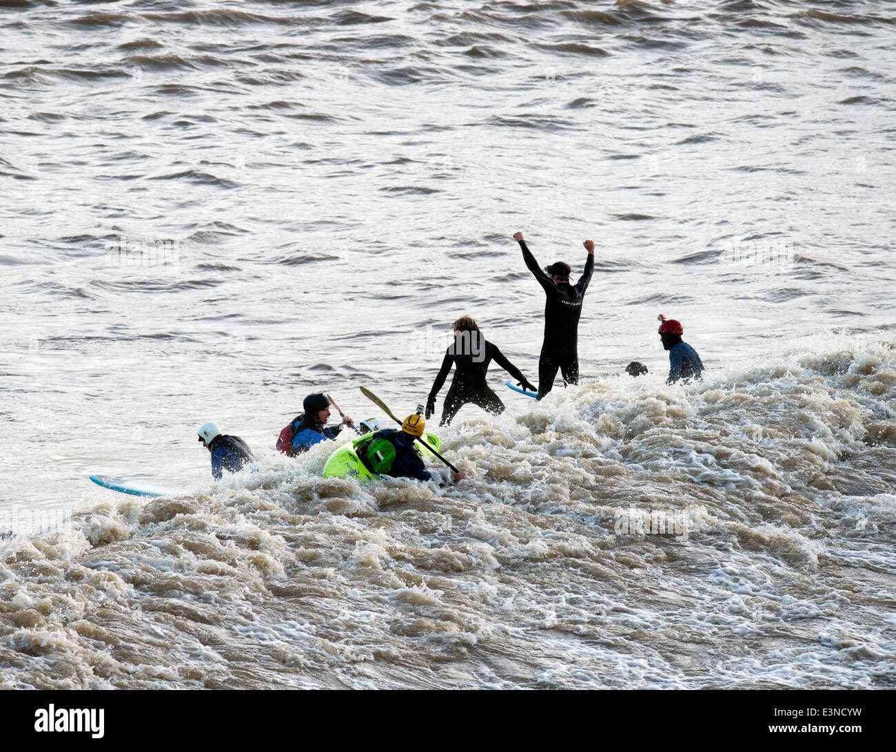 Surfer und Kanuten Reiten der Severn Bore am Newnham auf Severn, Gloucestershire UK 2014 Stockfoto