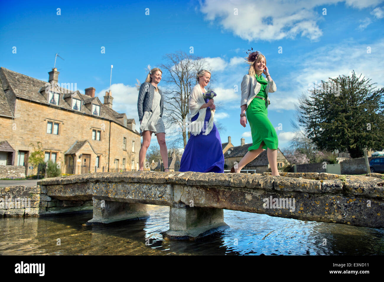 Hochzeitsgäste Kreuz eine steinerne Brücke im Dorf von Lower Slaughter, Gloucestershire UK Stockfoto