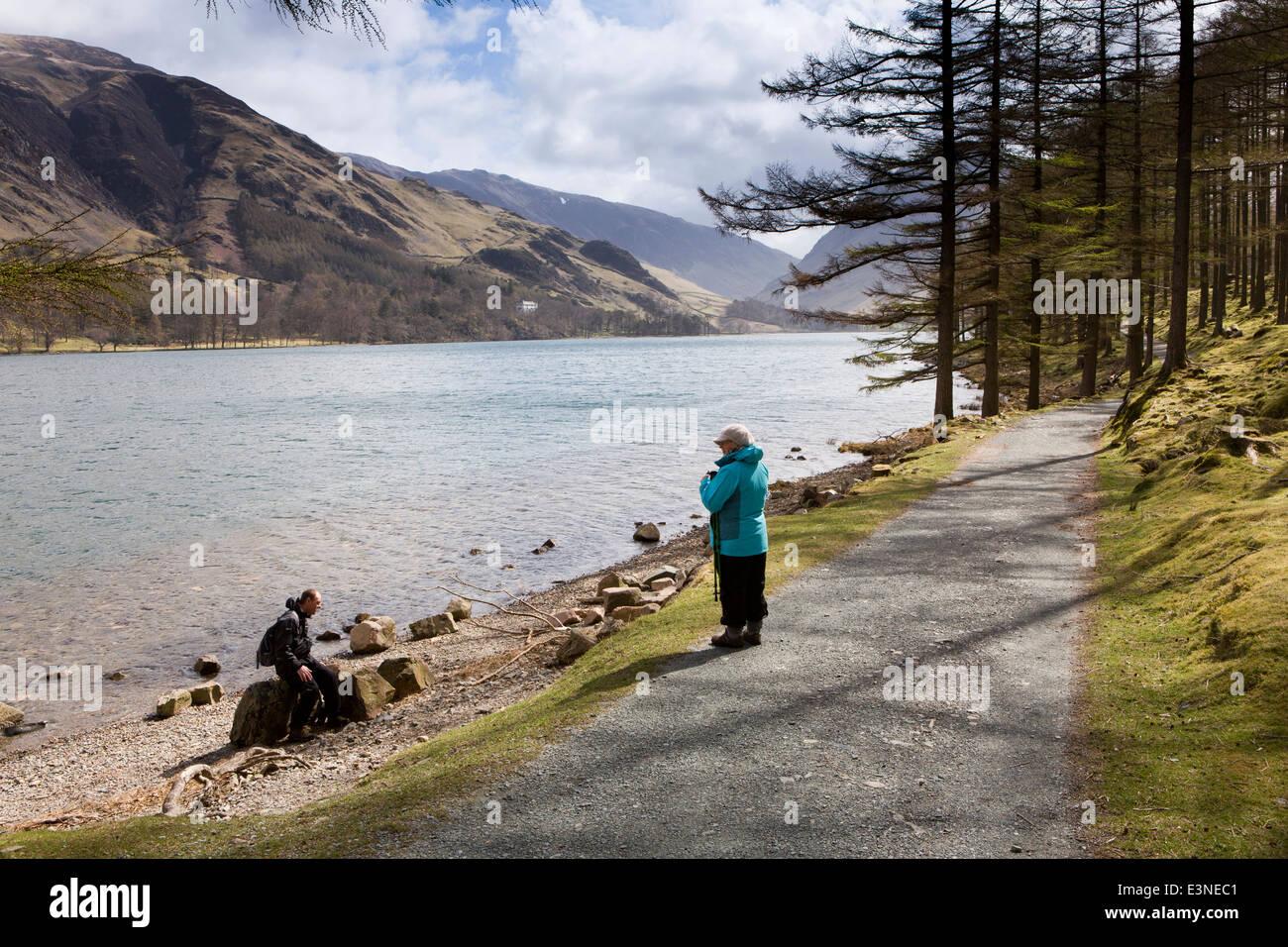 UK, Cumbria, Lake District, Buttermere, Wanderer ruht auf Uferweg durch Burtness Wood Stockfoto