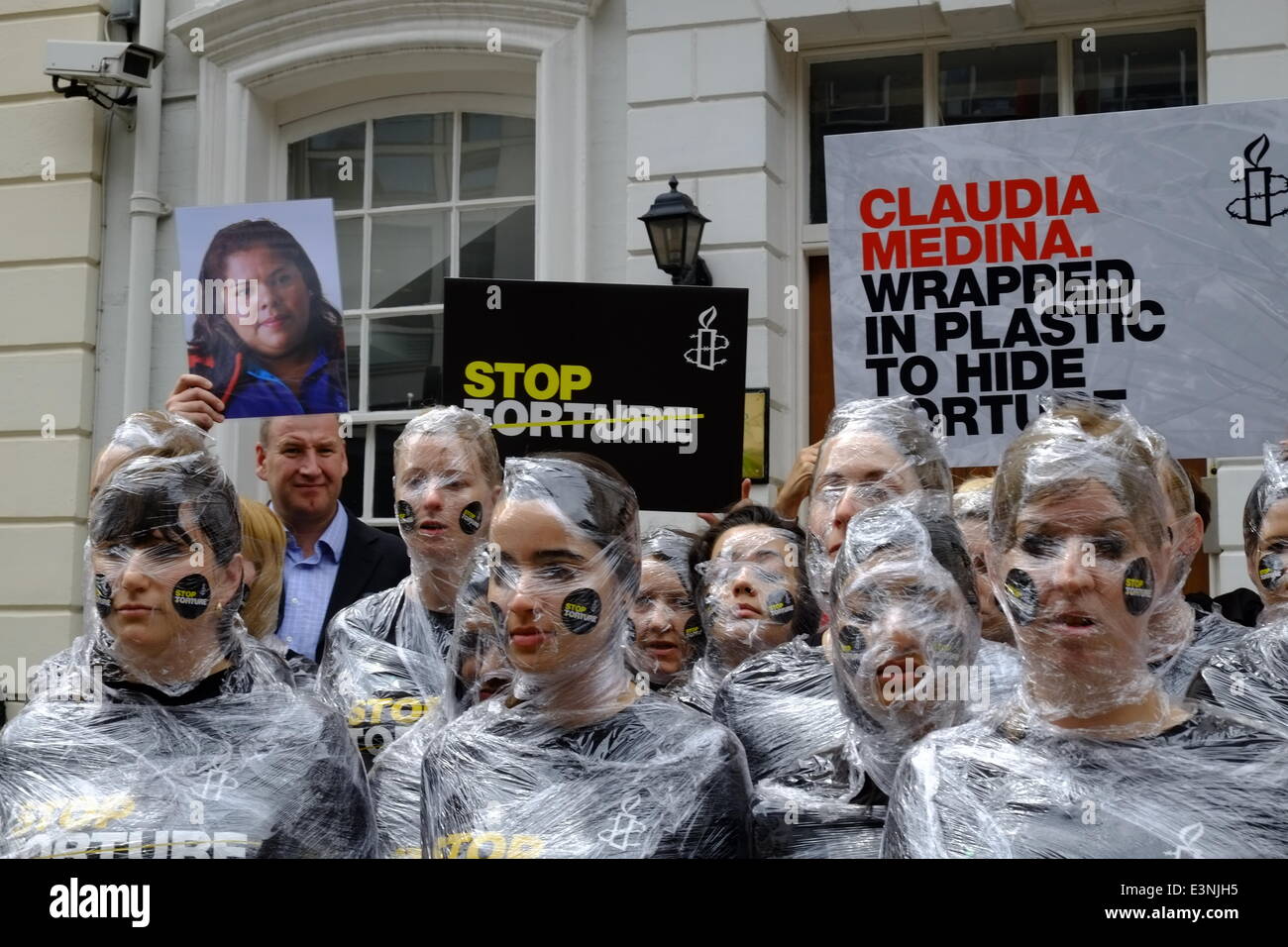 London, UK. 26. Juni 2014. 30 Frauen, markieren Sie bedeckte Kopf bis Fuß in Kunststoff im Fall von Claudia Medina, eine Mutter von drei in Mexiko, die im Jahr 2012 gefoltert wurde. Ihre Qual enthalten wird eingewickelt in Plastikplanen von Militärs, Blutergüsse an ihrem Körper während der Schläge zu minimieren. Bildnachweis: Rachel Megawhat/Alamy Live-Nachrichten Stockfoto