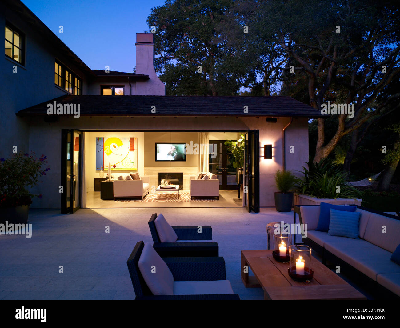 Blick in den beleuchteten Wohnzimmer Terrasse außen Steinhaus, Atherton, Kalifornien, USA. Stockfoto