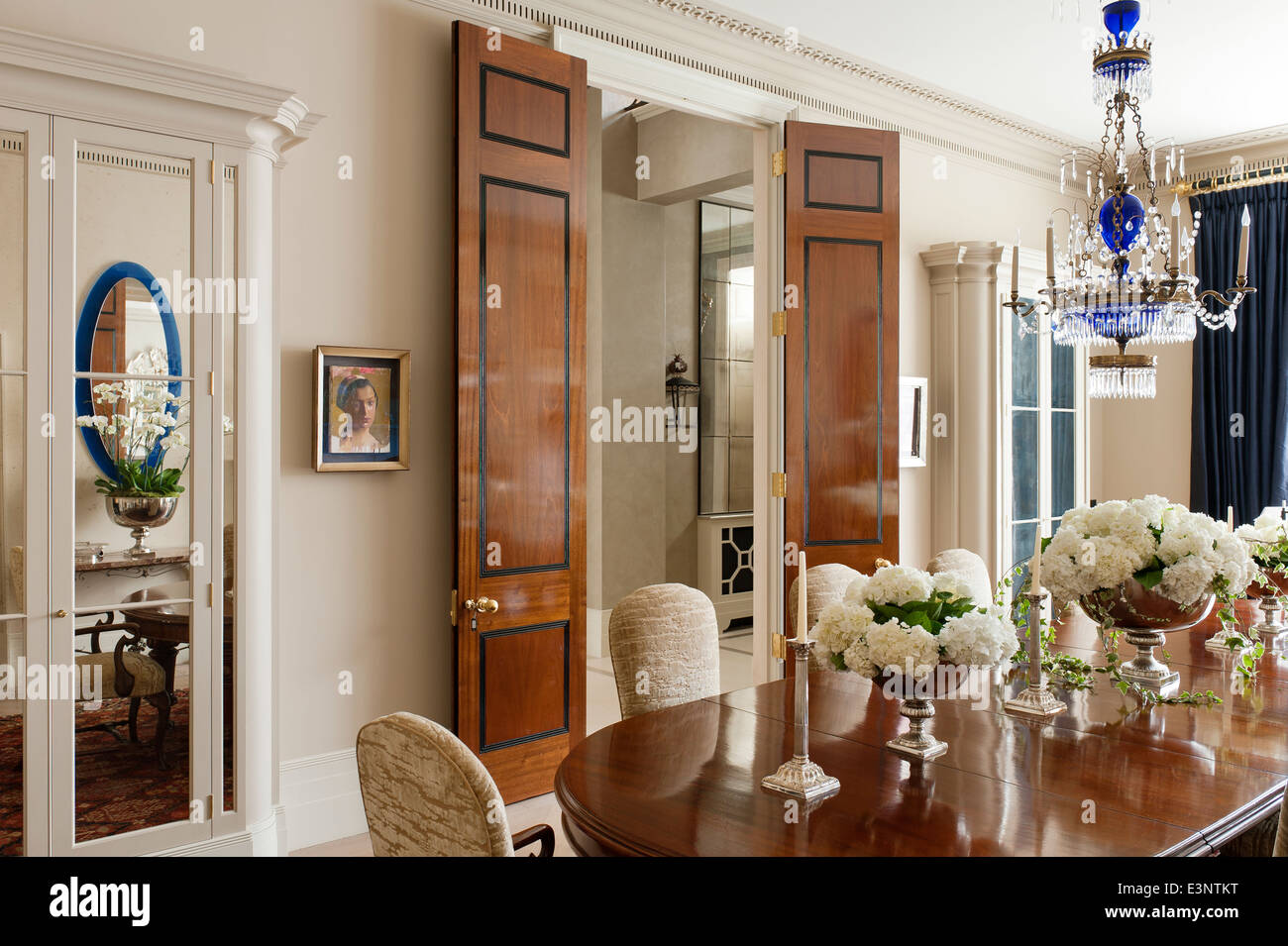 Russischen Stil Messingbeschläge und Kobaltblau Kronleuchter über dem Esstisch mit Reproduktion Queen Anne Dreiblatt Esszimmerstühle. Stockfoto