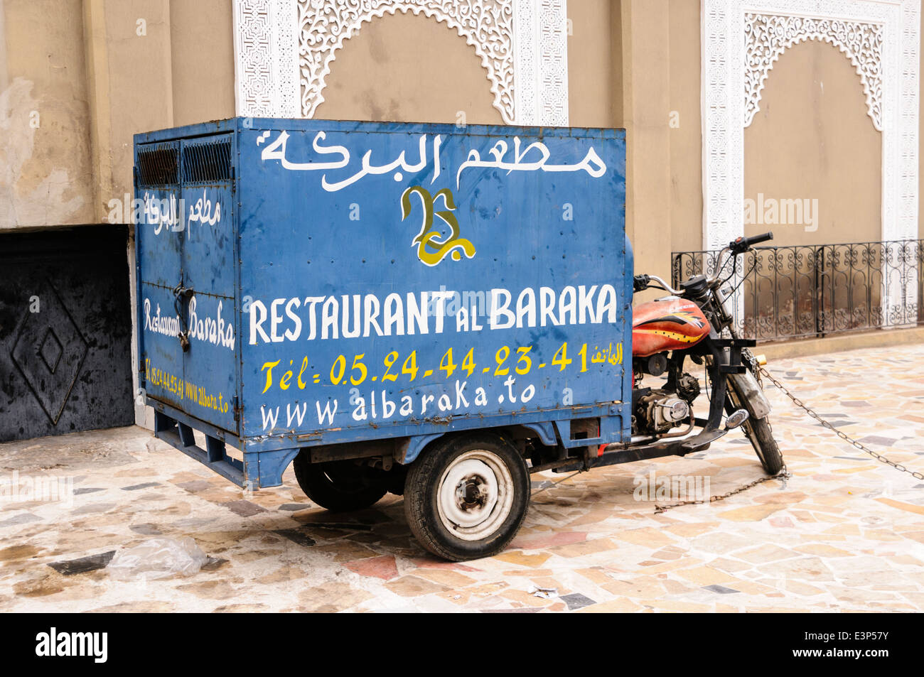 Ein Motorrad van, die zu einem Restaurant, mit handbemalten Werbung in Französisch und Arabisch, Marrakesch, Marokko. Stockfoto