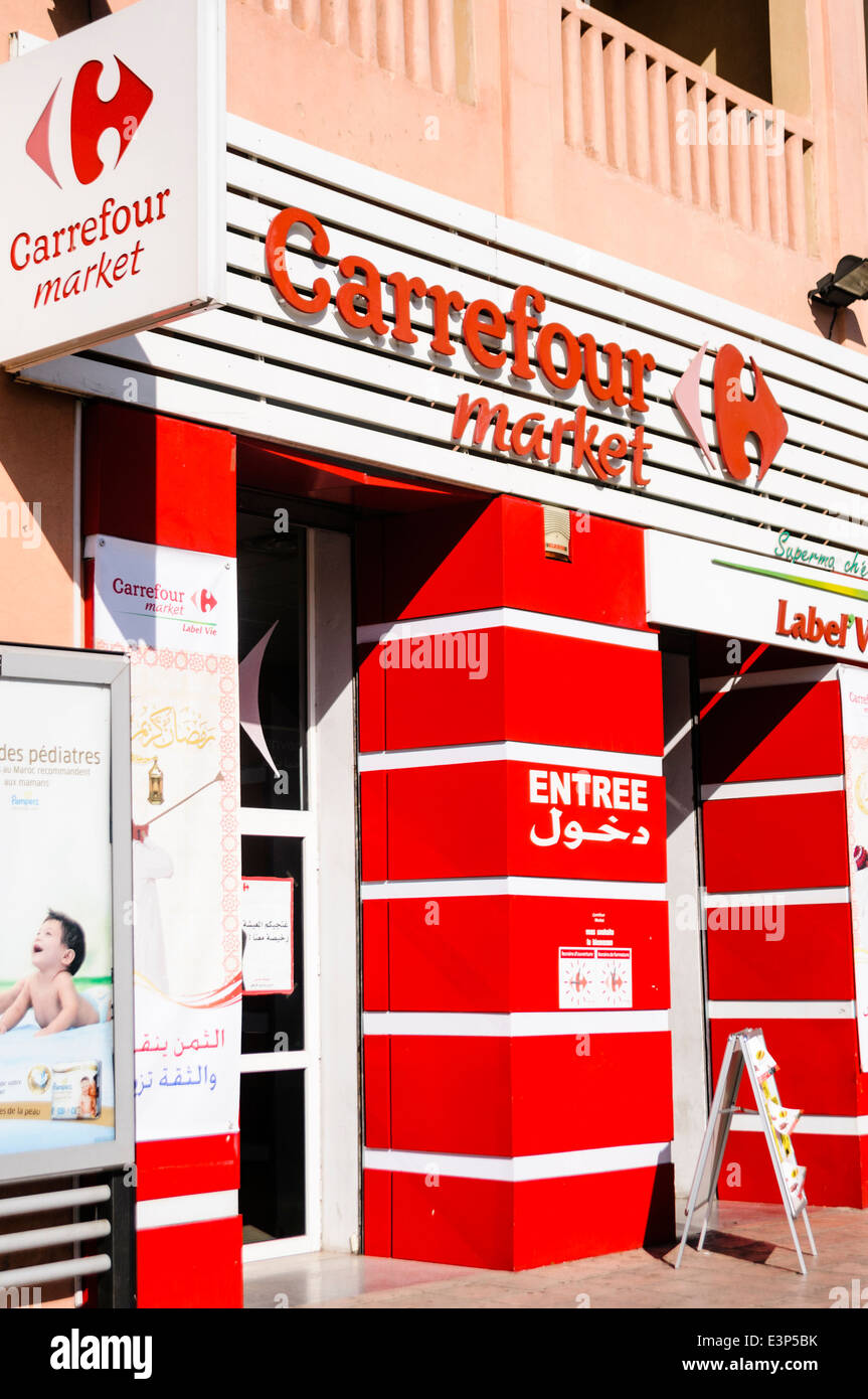 Rote und weiße Schilder mit Logo vor dem Eingang zu einem Carrefour Shop, eine berühmte französische Supermarktkette. Stockfoto