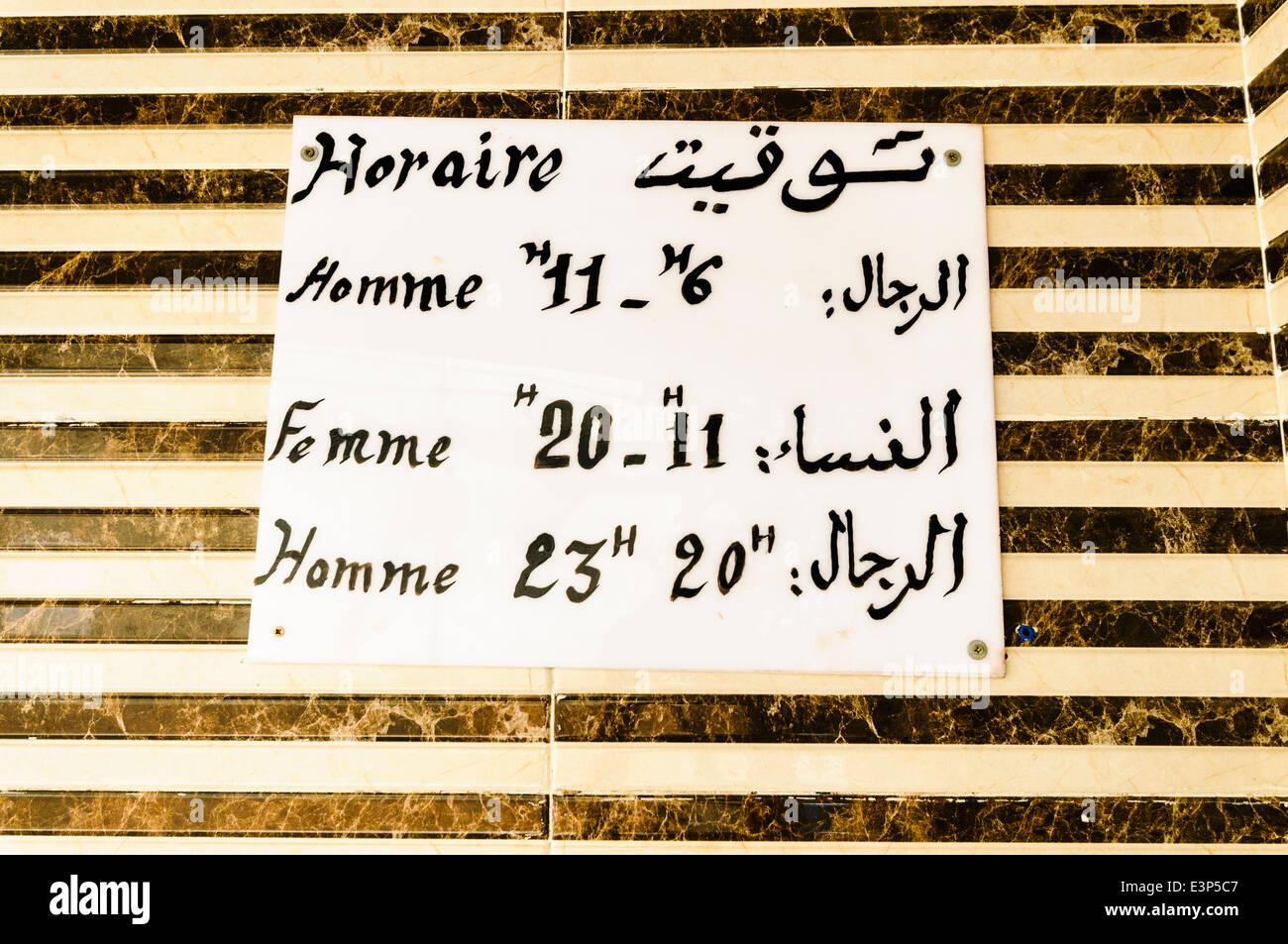 Hand schriftliche Öffnungszeiten Zeitplan in Arabisch und Französisch für Männer und Frauen für die Dampfbäder in Marrakesch, Marokko Stockfoto