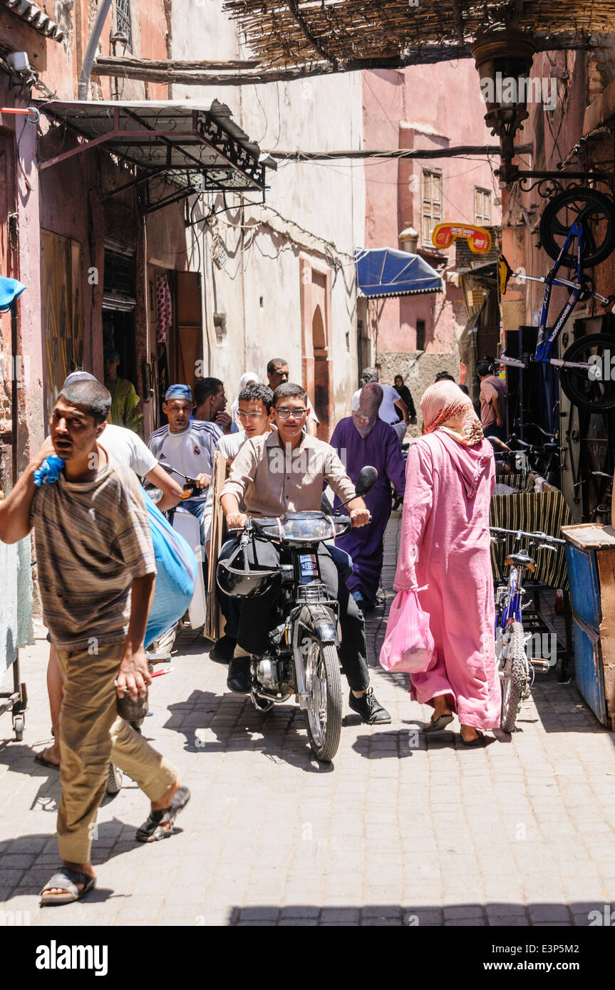 Viele Leute auf verschiedene Verkehrsträger entlang einer engen Straße in der Medina, Marrakesch, Marokko, Stockfoto