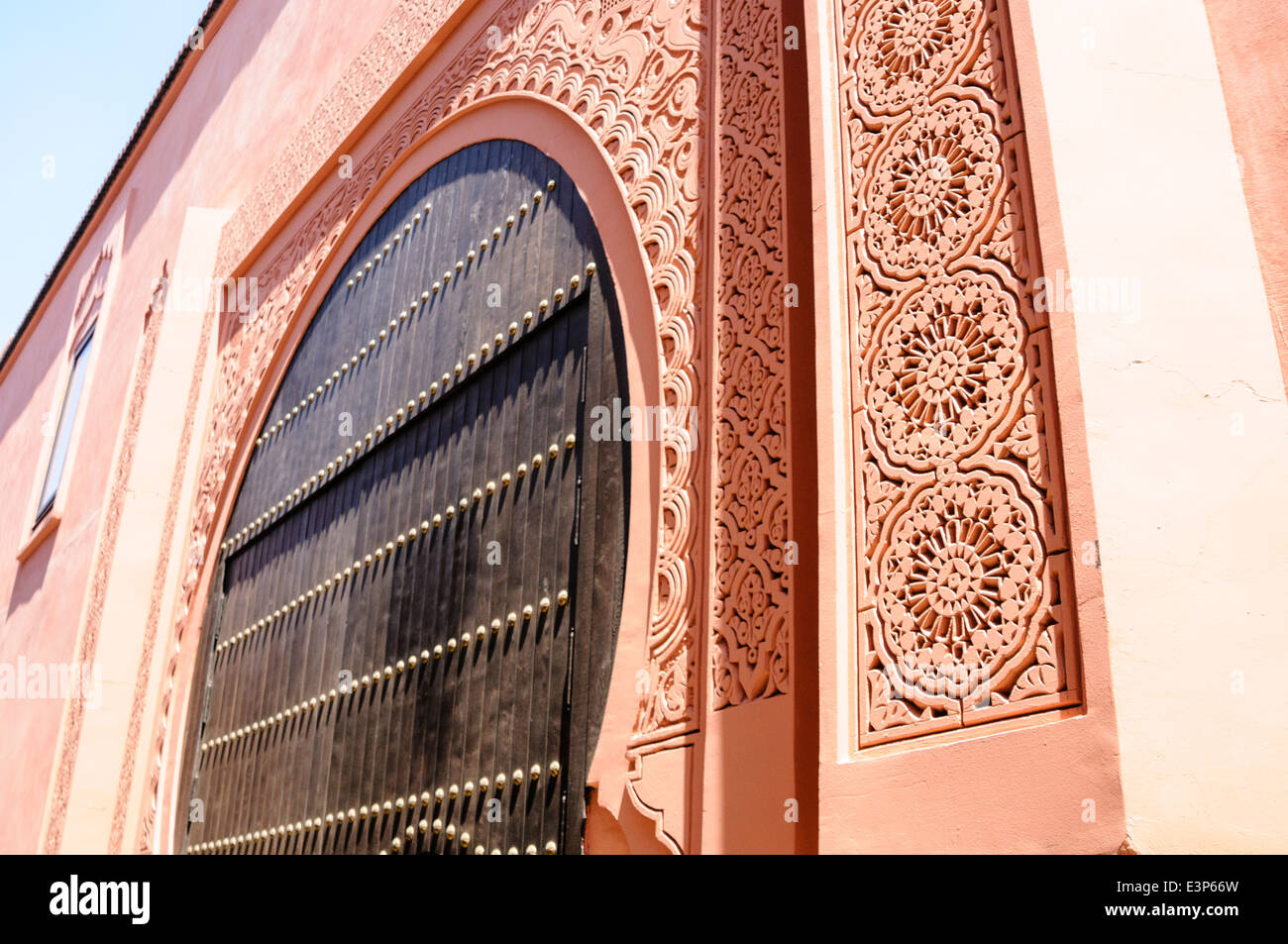 Kunstvoll geschnitzten Mauerwerk um die Tür eines Gebäudes in Marrakesch, Marokko Stockfoto