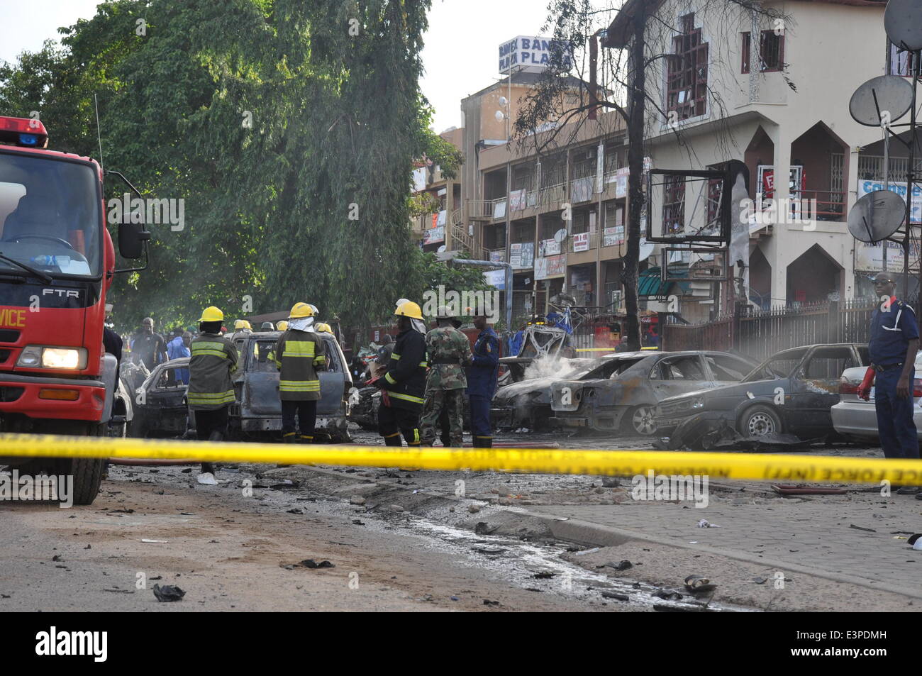 Abuja. 25. Juni 2014. Feuerwehrleute sind am Ort der Explosion einer Bombe im zentralen Geschäftsviertel in Nigerias Hauptstadt Abuja, am 25. Juni 2014 gesehen. Die Explosion ereignete sich in einem Einkaufszentrum in der Nähe einen großen Markt in der nigerianischen Hauptstadt, sagte Zeugen. Keine offiziellen Opferzahlen gegeben, aber Zeugen sagten aus, sie Leichen sahen. © Ikechukwu Ibe/Xinhua/Alamy Live-Nachrichten Stockfoto