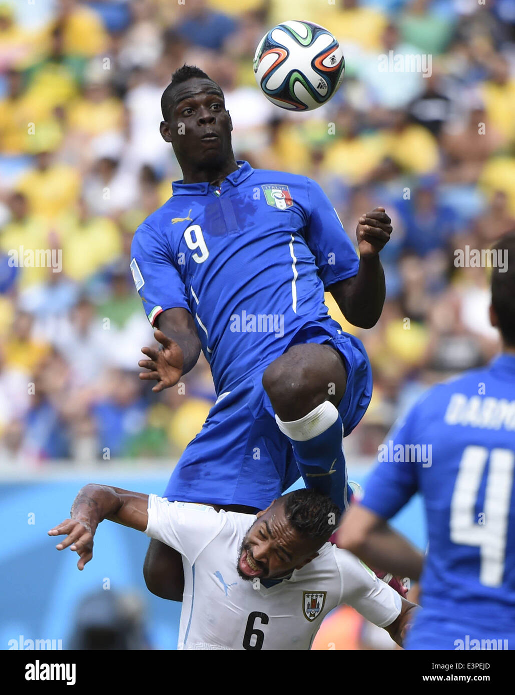 Natal, Brasilien. 24. Juni 2014. Italiens Mario Balotelli (nach oben) springt für den Ball während einer Gruppe D-match zwischen Italien und Uruguay der FIFA WM 2014 an der Estadio Das Dunas Stadion in Natal, Brasilien, 24. Juni 2014. © Lui Siu Wai/Xinhua/Alamy Live-Nachrichten Stockfoto