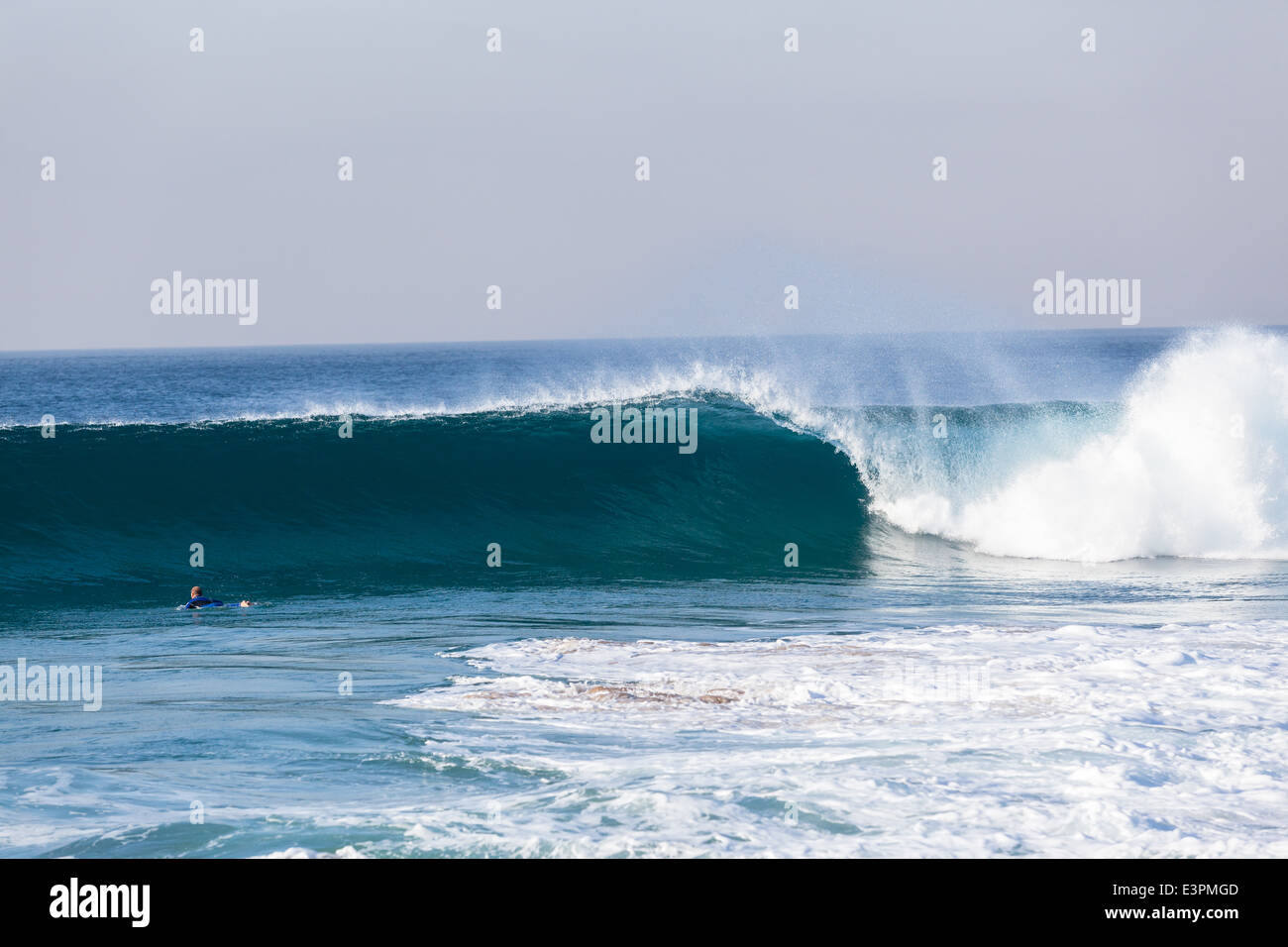 Blauen Ozeanwelle entlang der flachen Strand Sandbänke mit unbekannten Surfer Absturz Stockfoto