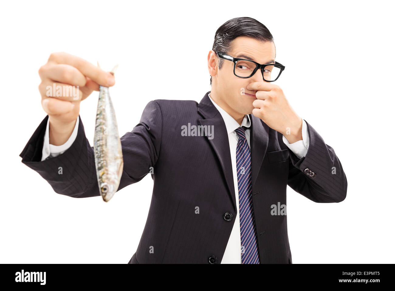 Junger Geschäftsmann, der einen stinkenden Fisch hält Stockfoto