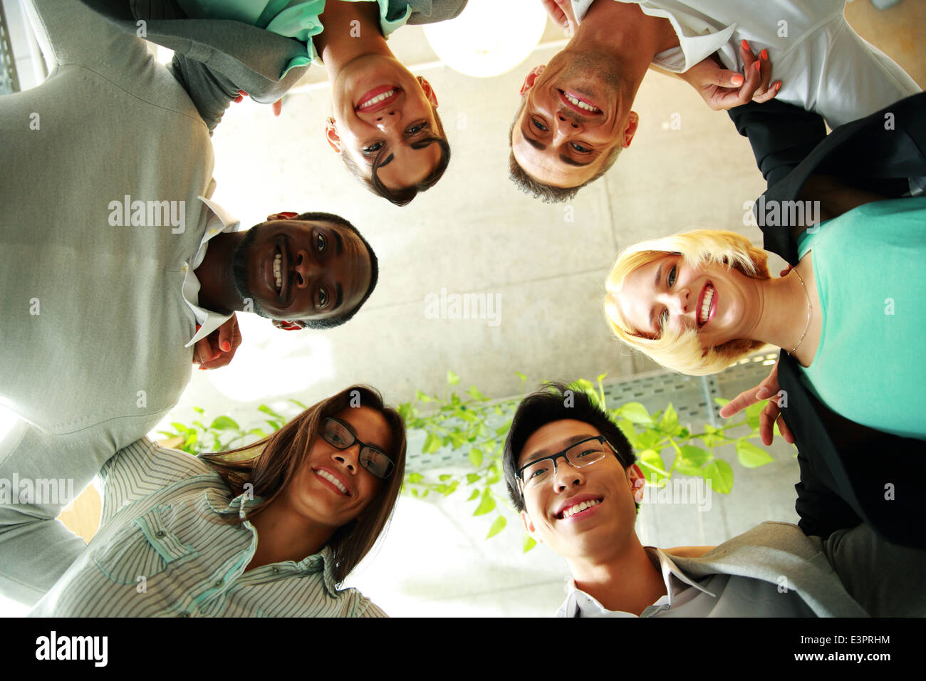 Lächelnde Geschäftsleute mit ihren Köpfen zusammen stellvertretend Konzept der Ftiendship und Teamarbeit Stockfoto