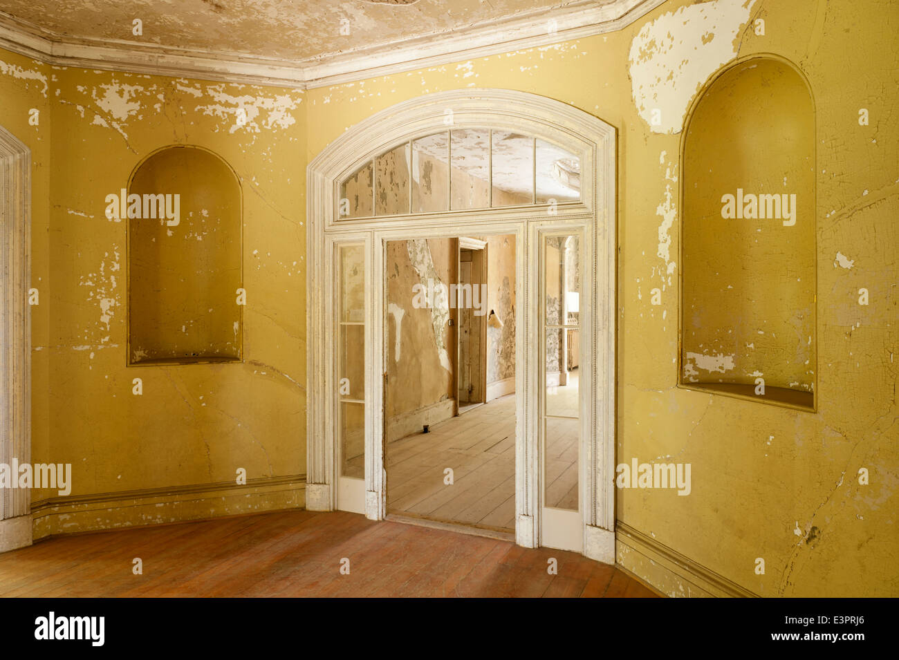 Glastür mit Oberlichtern im Zimmer mit gerissenen Wandfarbe und Nischen Stockfoto