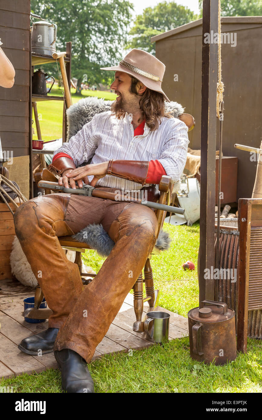 Lauch, Staffordshire, England.22nd Juni 2014, A Western Weekend, Mann, gekleidet wie ein Cowboy auf einem Stuhl sitzend & lachen. Stockfoto