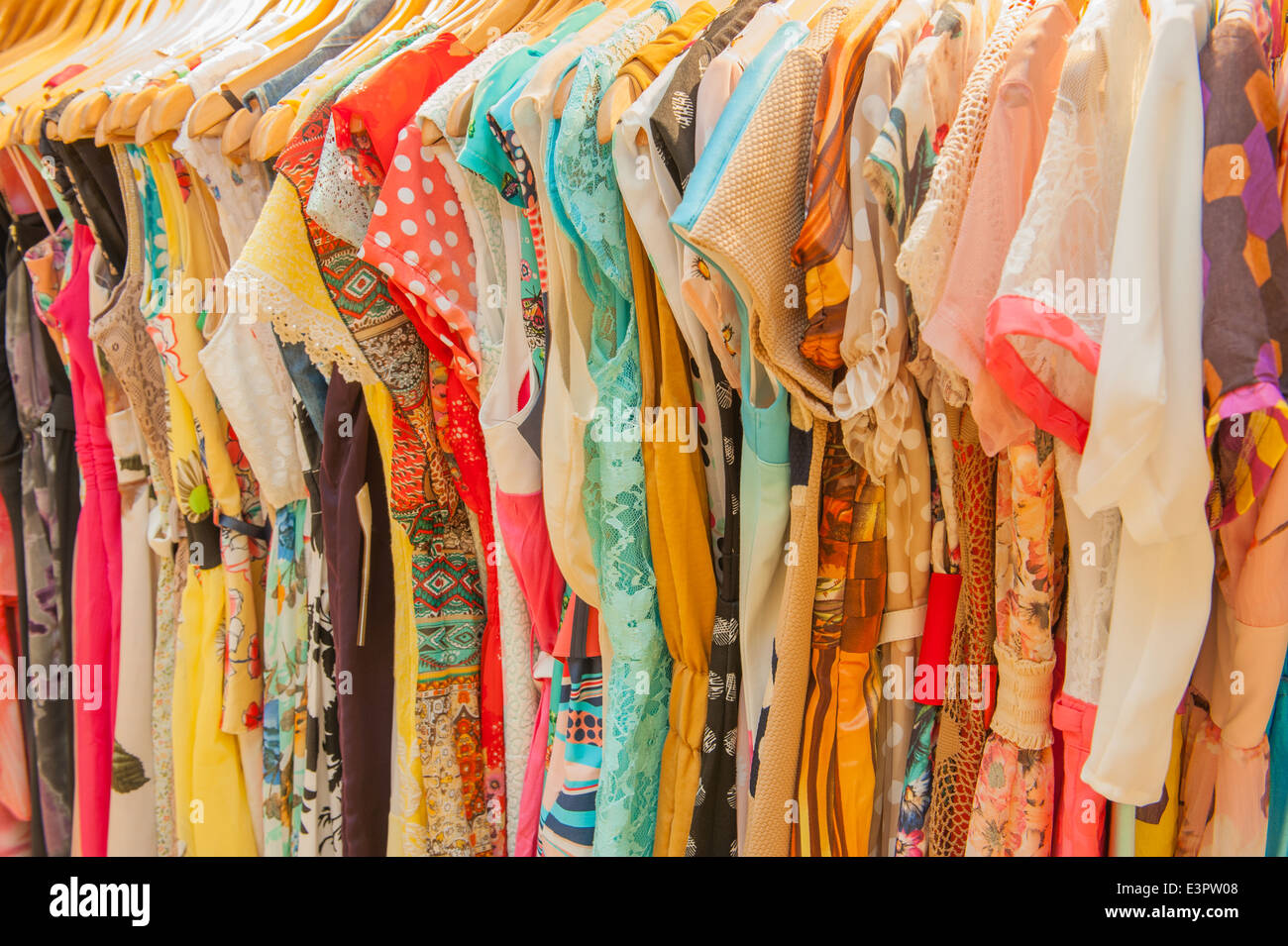 Vielzahl von bunten Damen Sommer Mode Klamotten auf der Schiene im Ladengeschäft Stockfoto