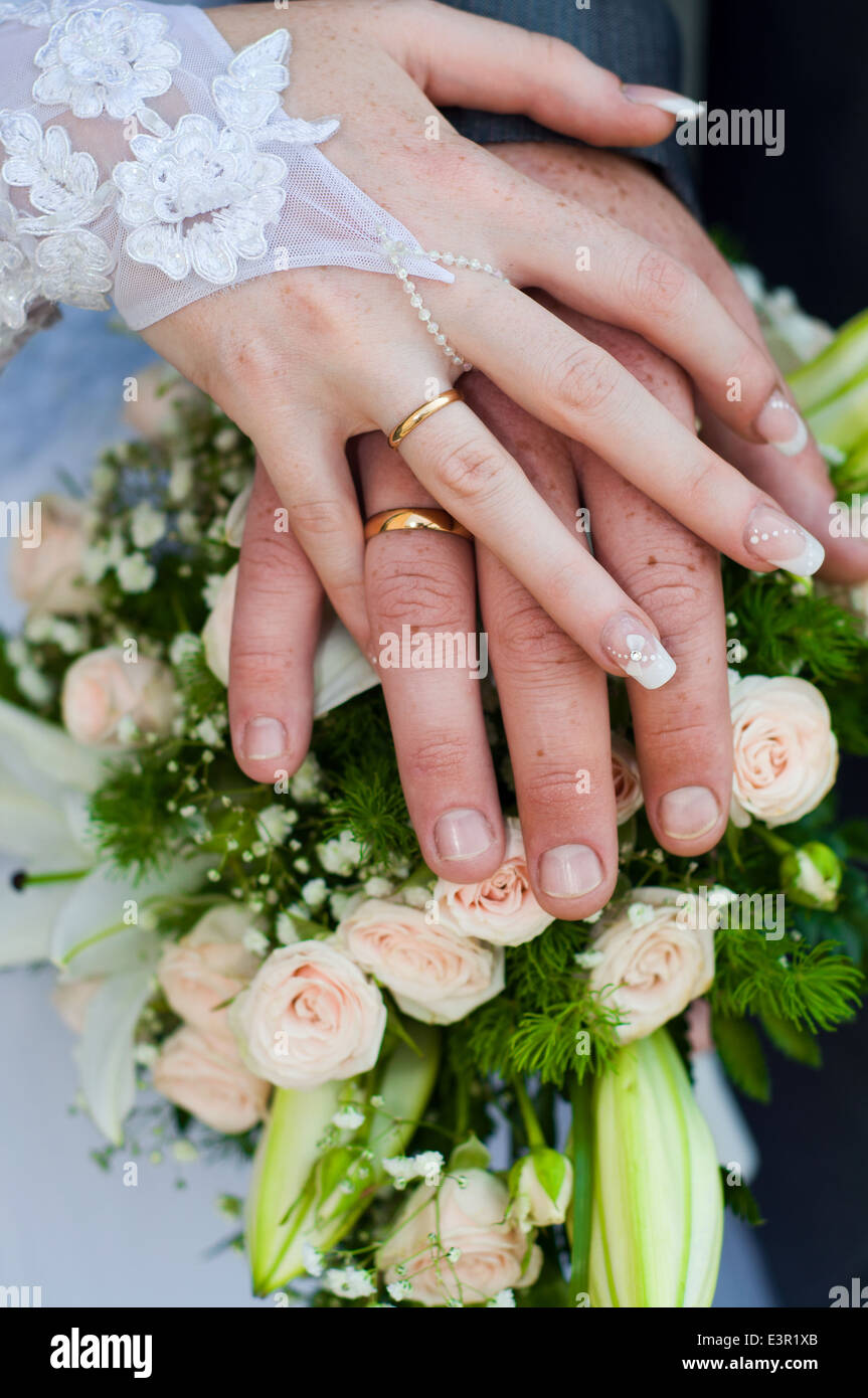 Sommersprossige Hände der Braut und des Bräutigams zeigt die Trauringe Stockfoto
