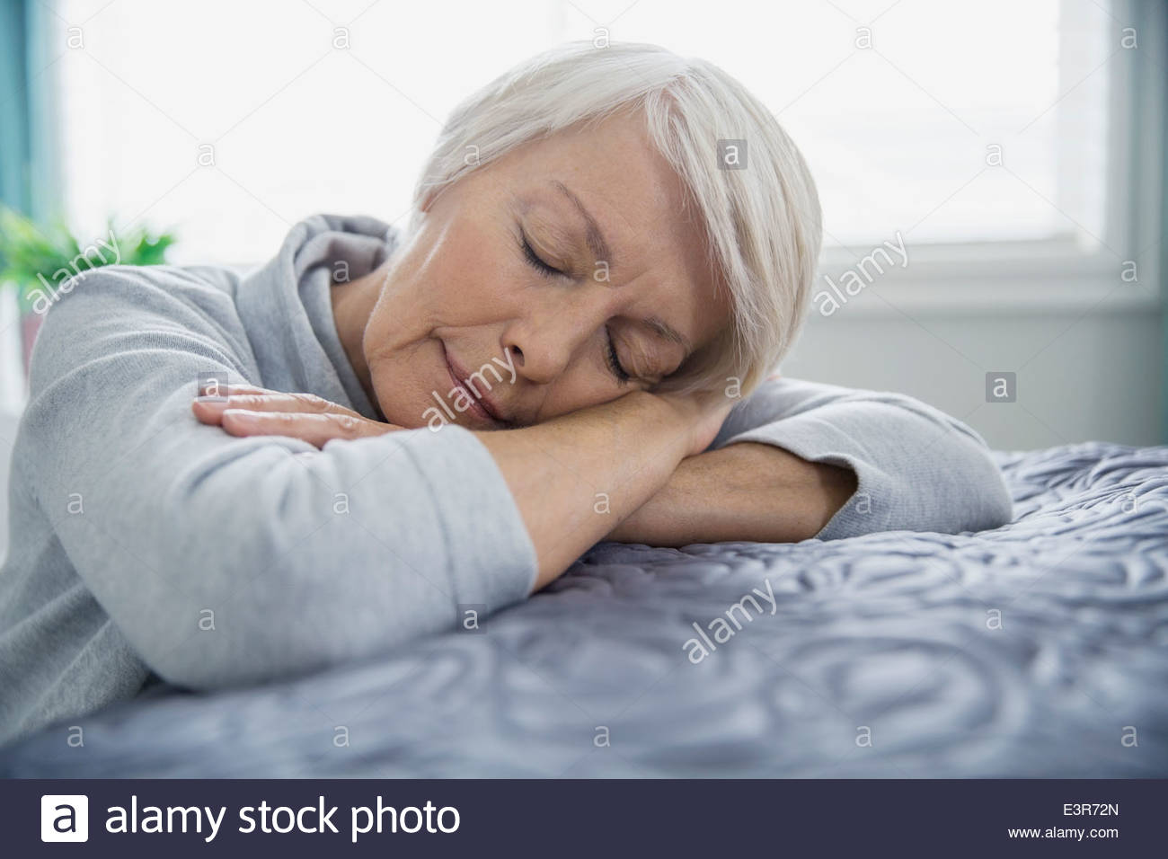 Müde Frau mit auf Bett mit geschlossenen Augen Stockfoto