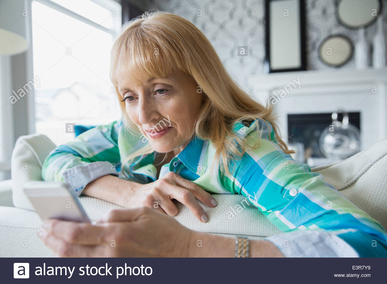 Frau von SMS-Nachrichten auf sofa Stockfoto